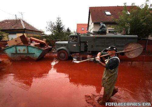 Un voluntar deplasandu-se prin raul de namol rosu din Devecser, Foto: Agerpres