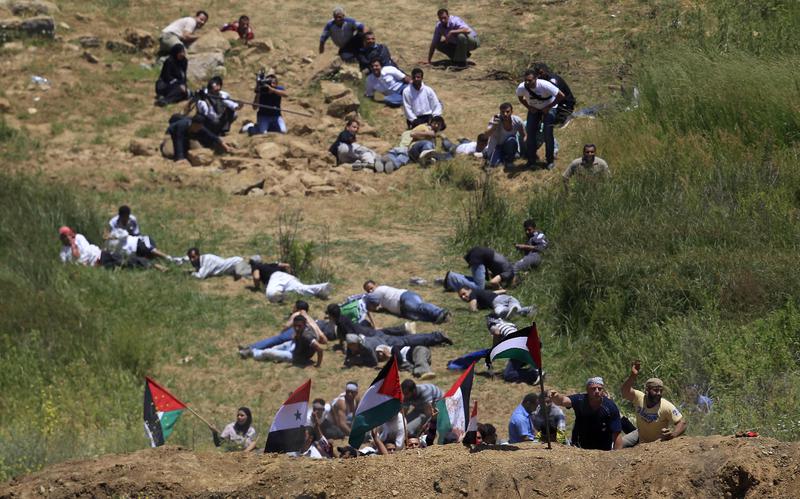 Protestatarii ferindu-se de gloantele garzilor israeliene, Foto: Reuters