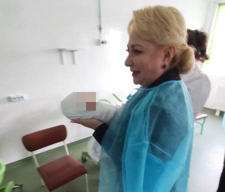 Viorica Dăncilă ține în brațe un nou născut, Foto: realitatea de vrancea