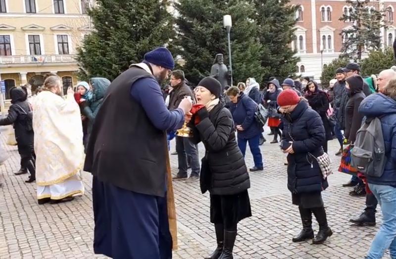 Credinciosi care se impartasesc la Cluj Napoca, in fata catedralei, Foto: Captura YouTube