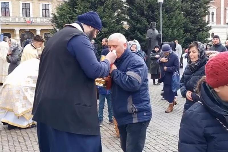 Credinciosi care se impartasesc la Cluj Napoca, in fata catedralei, Foto: Captura de ecran