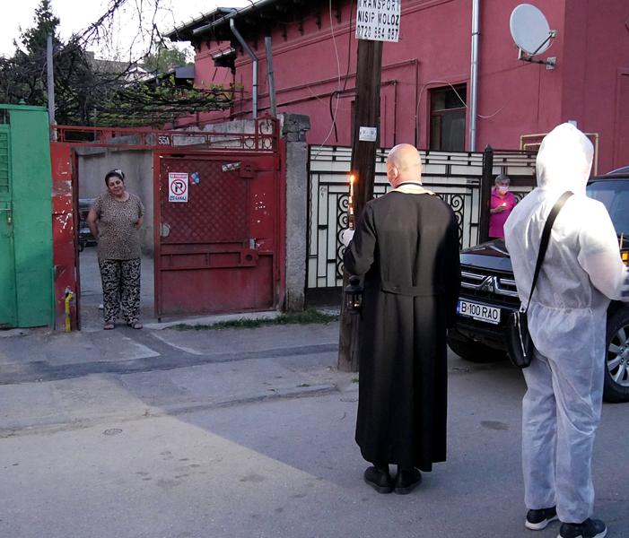 Preot și voluntar de la biserică împart lumina de Înviere, Paște 2020, Foto: Gabriel Bejan