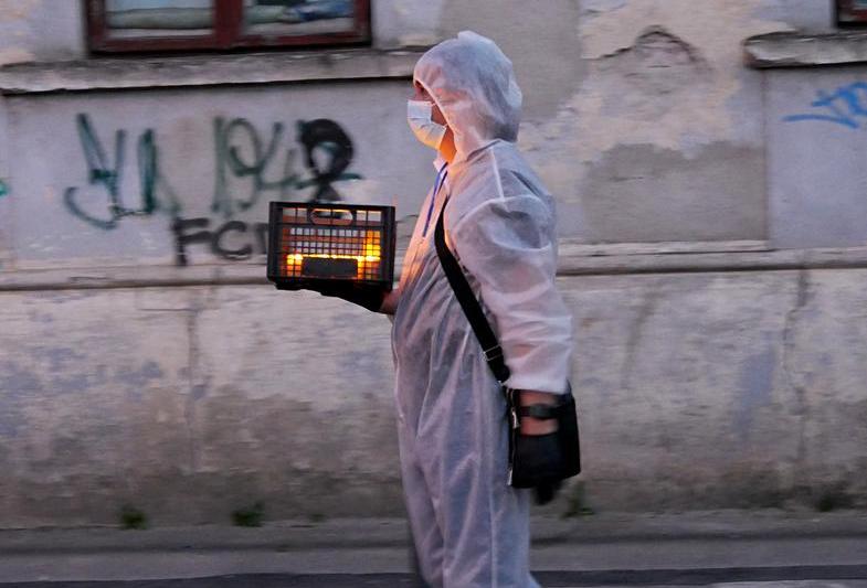 Voluntar împarte lumina de Înviere, Paște 2020, Foto: Gabriel Bejan