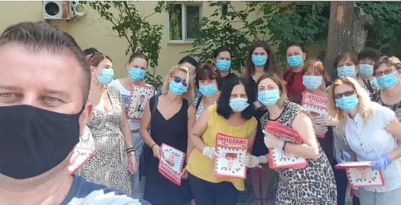 Angajati ai Caminului Craiova impartind integrame cu Olguta vasilescu, Foto: captura facebook