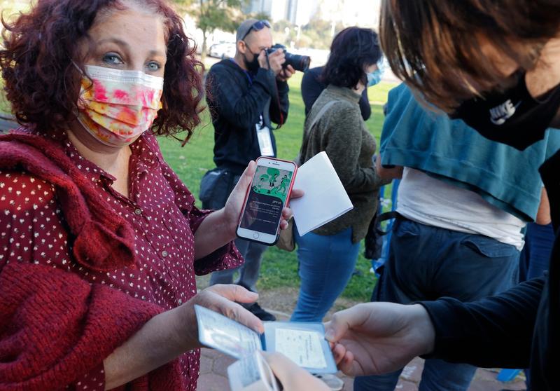 Persoana din Israel arata aplicatia care dovedeste ca este vaccinata, Foto: AFP / AFP / Profimedia