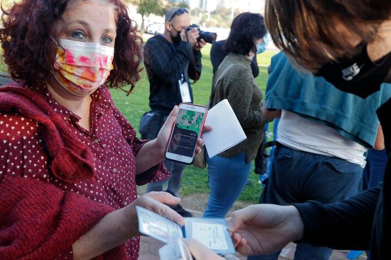 Persoana din Israel arata aplicatia care dovedeste ca este vaccinata, Foto: AFP / AFP / Profimedia