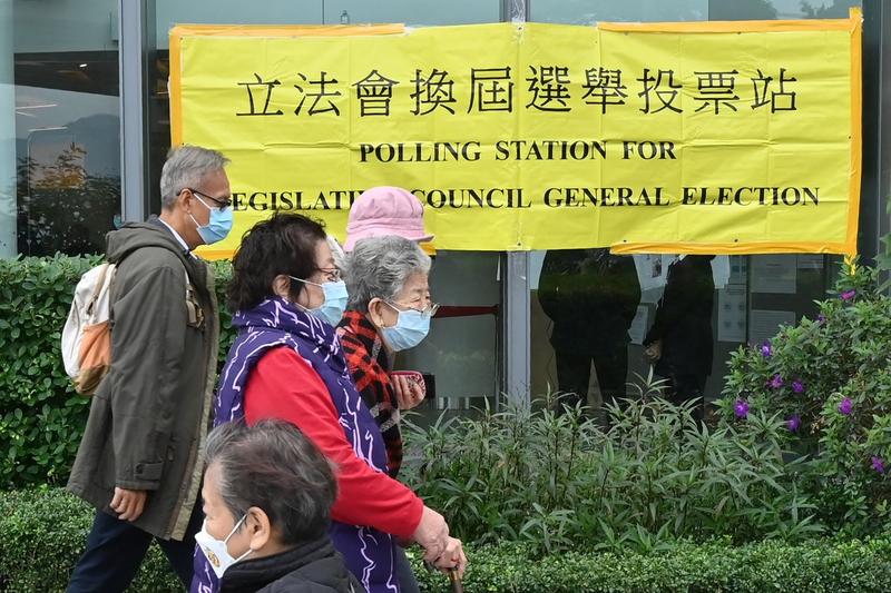Locuitori din Hong Kong ce trec pe langa o sectie de vot, Foto: PETER PARKS / AFP / Profimedia