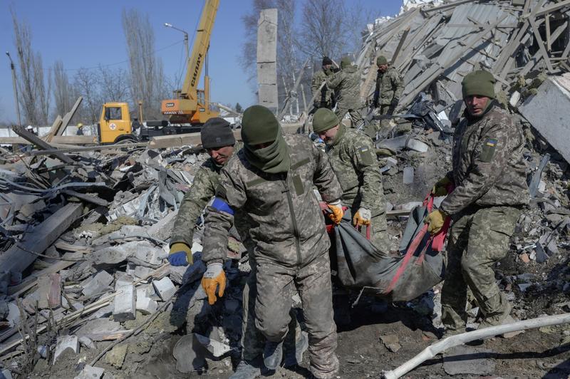 Militarii ucraineni scot de sub daramaturi un soldat mort dupa bombardarea scolii militare din Nikolaiev, Foto: Bulent Kilic / AFP / Profimedia