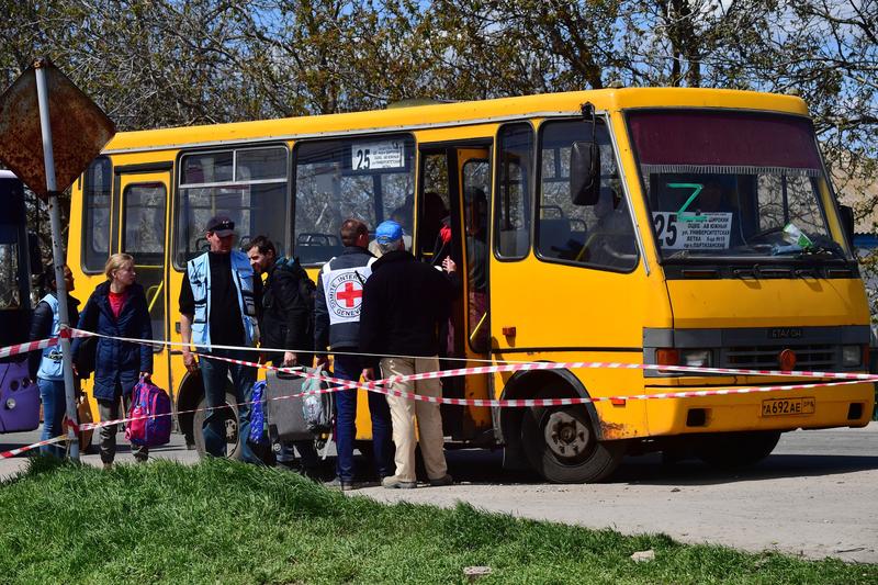 Un reprezentant al Crucii Rosii îi ajuta pe civilii din Mariupol sa urce intr-un autobuz de evacuare, Foto: Alexey Kudenko / Sputnik / Profimedia