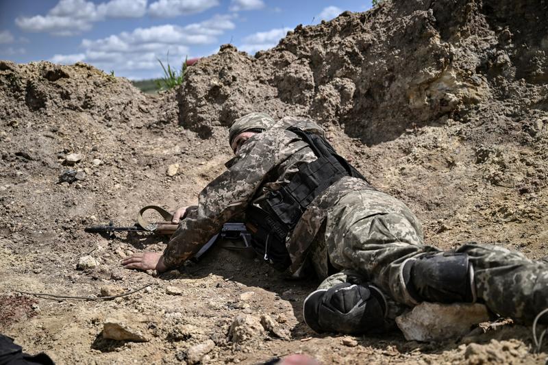 un militar ucrainean se adaposteste in timpul unor bombardamente in Donbas, Foto: Aris Messinis / AFP / Profimedia Images