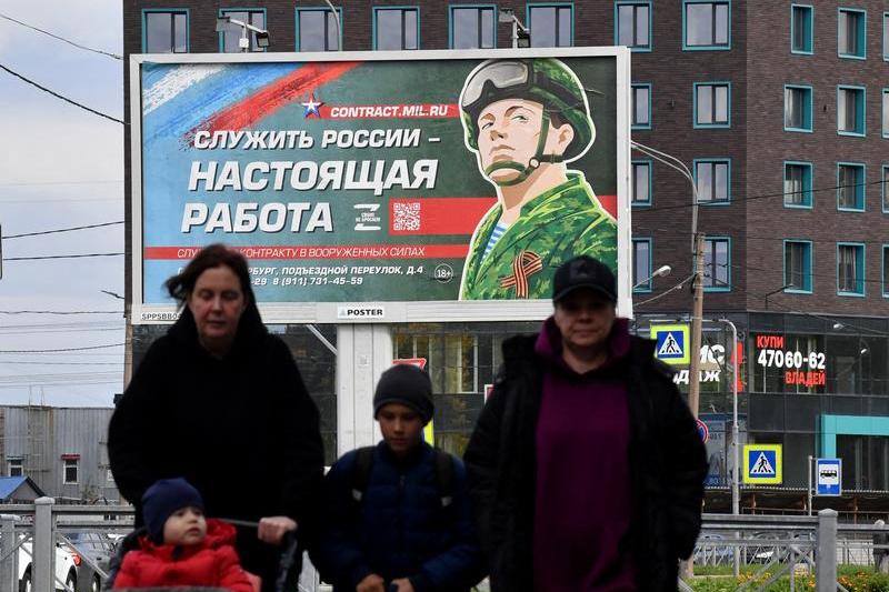 În Sankt Petersburg, un panou publicitar care promovează serviciul militar prin contract cu imaginea unui militar și sloganul Servirea Rusiei este o slujbă adevărată, Foto: Olga MALTSEVA / AFP / Profimedia