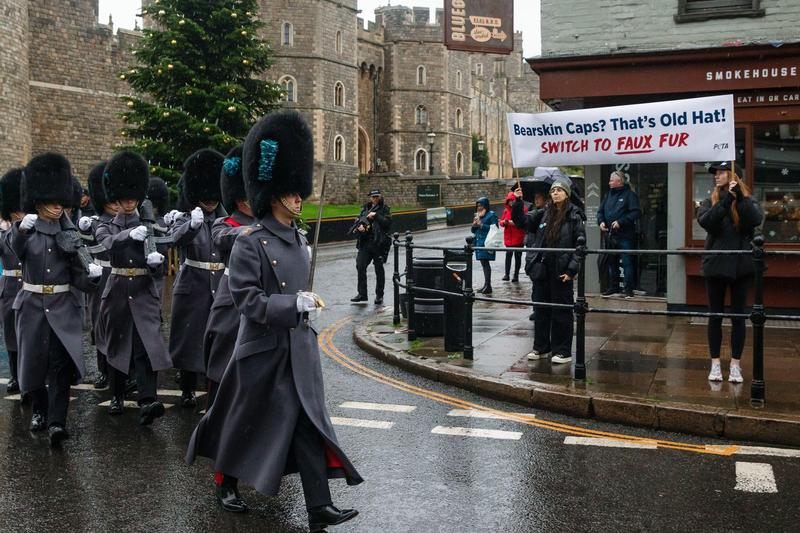 membri ai Garzii Regale purtand bearskins, in timp ce protestatari PETA afiseaza o pancarta care cere inclocuirea blanii naturale de urs cu o varianta artificiala, Foto: Mark Kerrison / Alamy / Alamy / Profimedia