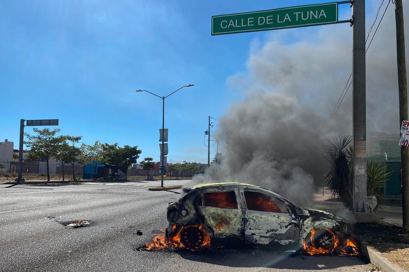 Mașină incendiată în timpul unei operațiuni a forțelor de securitate mexicane care l-au arestat pe fiul lui El Chapo, Ovidio Guzman, Foto: Juan Carlos CRUZ / AFP / Profimedia