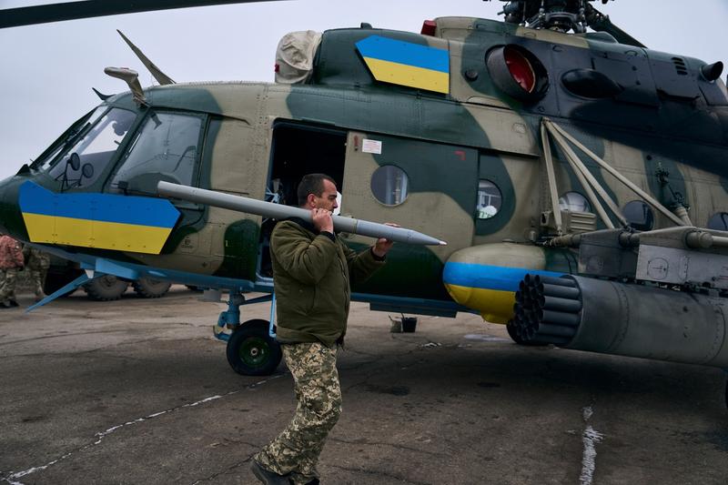Soldat încărcând lansatoarele unui elicopter ucrainean la o bază din apropierea Bahmut, Foto: LIBKOS / AP / Profimedia