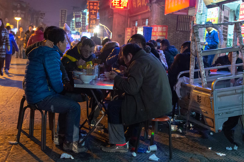 Chinezi luând masa pe stradă în orașul Luoyang din provincia Henan, Foto: DreamsTime / Mirko Kuzmanovic