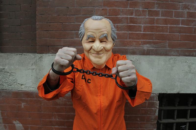Un bărbat poartă o masca de cauciuc cu fața lui Bernie Madoff, de numele căruia ămâne legată cea mai mare fraudă financiară din istorie, Foto: TIMOTHY A. CLARY / AFP / Profimedia