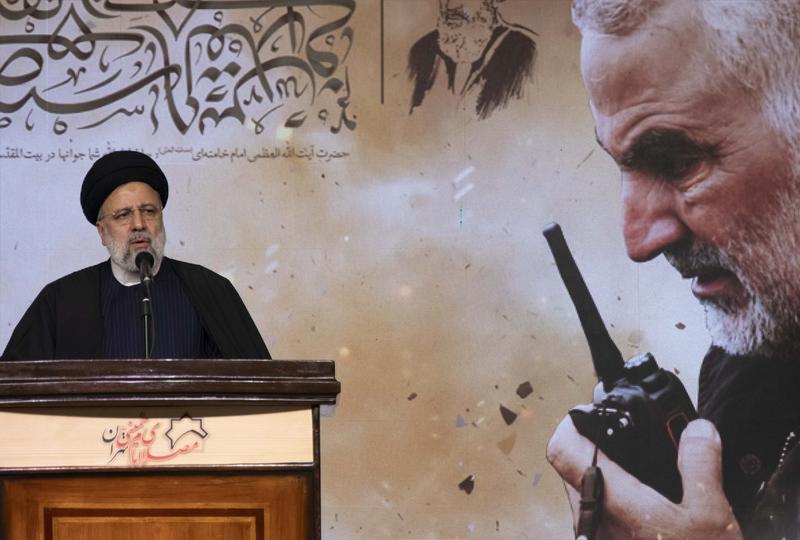 Președintele iranian Ebrahim Raisi având pe fundal o imagine cu generalul Qasem Soleimani, Foto: Morteza Nikoubazl / Zuma Press / Profimedia