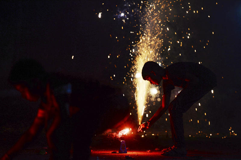 Un copil aprinde petarde și artificii de mari dimensiuni, Foto: Arun SANKAR / AFP / Profimedia