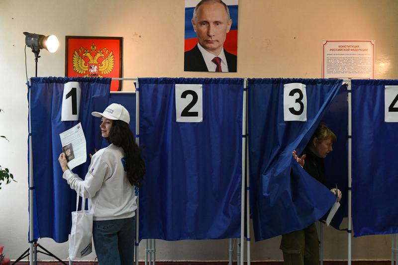Alegeri prezidentiale rusesti in Donetk, din Ucraina, in timp ce portretul lui Putin „vegheaza” sectia de vot, Foto: STRINGER / AFP / Profimedia