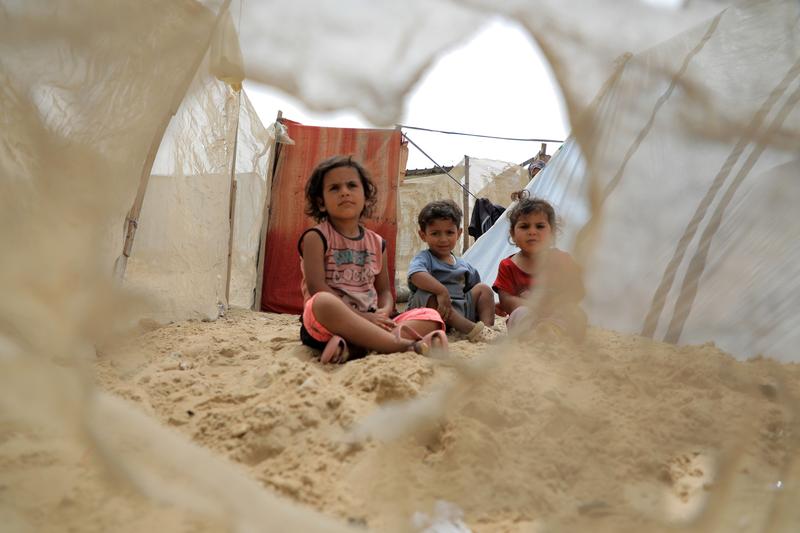 Trei copii palestinieni evacuați din Rafah sunt văzuți pe o plajă din orașul Khan Younis din sudul Fâșiei Gaza, pe 10 mai 2024., Foto: Rizek Abdeljawad / Xinhua News / Profimedia