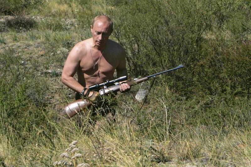 Vladimir Putin, în 2010, cu o armă de vânătoare și cu bustul gol, în regiunea rusă Tuva, la granița cu Mongolia, Foto: Dmitry Astakhov / AP / Profimedia