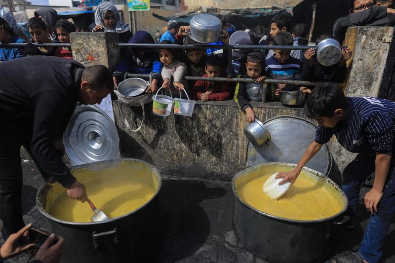 Copii palestinieni strămutați se adună pentru a primi alimente la un punct de donații din Rafah, în sudul Fâșiei Gaza, pe 7 martie 2024., Foto: Middle East Images/ABACA / Abaca Press / Profimedia