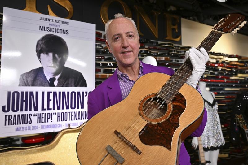 Directorul executiv al casei de licitații Julien's Auctions, Martin J. Nolan, prezintă chitara pierdută a lui John Lennon vândută cu aproape 3 milioane de dolari, Foto: zz/NDZ/STAR MAX/IPx / AP / Profimedia