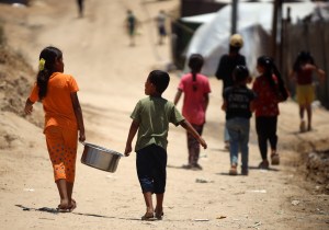 Copii palestinieni strămutați primesc alimente într-o tabără unde locuiesc din cauza bombardamentelor israeliene asupra Fâșiei Gaza, în Deir el-Balah, pe 26 iunie 2024. Foto: Majdi Fathi/NurPhoto/Shutterstoc / Shutterstock Editorial / Profimedia