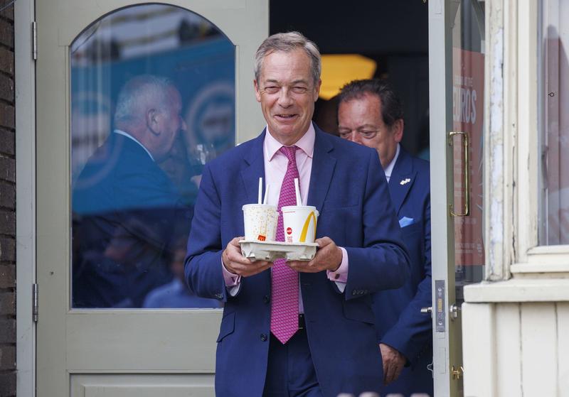 Nigel Farage, cu o tavă cu 4 milkshake-uri de banane. Mai devreme, o femeie i-a aruncat în față un milkshake de banane, Clacton on Sea, Marea Britanie, 4 iunie 2024., Foto: Mark Thomas / Shutterstock Editorial / Profimedia Images
