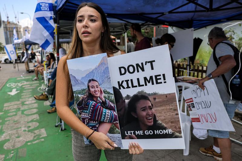 O prietenă a studentei israeliene Noa Argamani, răpită de Hamas în asaltul din 7 octombrie, ține o pancartă cu chipul tinerei, la o demonstranție din Tel Aviv, pe 18 octombrie 2023., Foto: AHMAD GHARABLI / AFP / Profimedia
