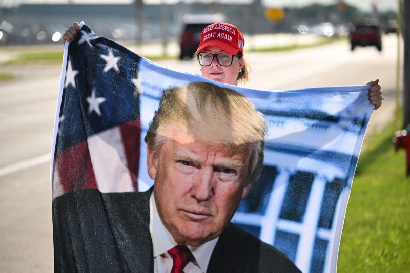 Un susținător al fostului președinte al SUA și candidat republican la președinție Donald Trump așteaptă lângă Aeroportul Internațional Milwaukee Mitchell, Wisconsin, la 14 iulie 2024, pentru a încerca să vadă avionul său aterizând. Foto: Patrick T. Fallon / AFP / Profimedia