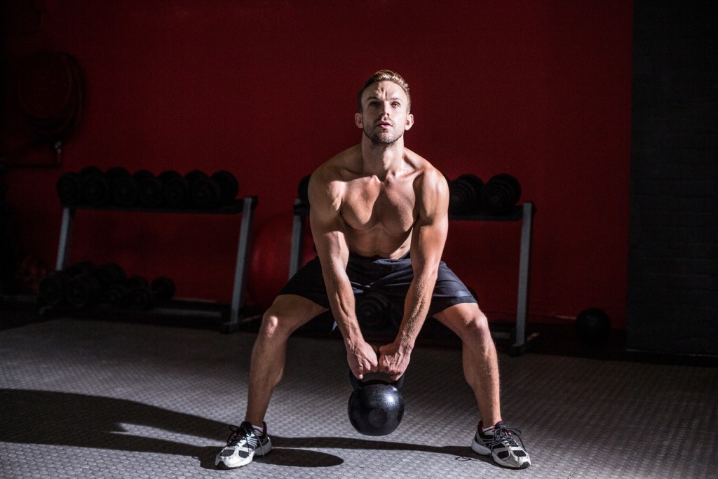 Sportiv folosind o ganeră kettlebell. Foto: - / Wavebreak / Profimedia