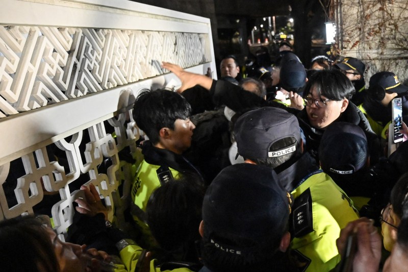 Poliția încearcă să oprească oamenii care încearcă să intre în Adunarea Națională la Seul, după ce președintele a declarat legea marțială / FOTO: JUNG YEON-JE / AFP / Profimedia