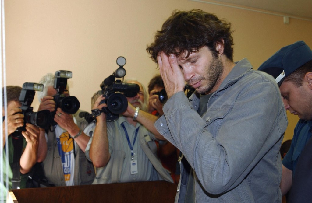 31 iulie 2003 - Cântărețul Betrand Cantat este escortat la tribunal în procesul privind uciderea iubitei, Marie Trintignant. Foto: ERIC FEFERBERG / AFP / Profimedia