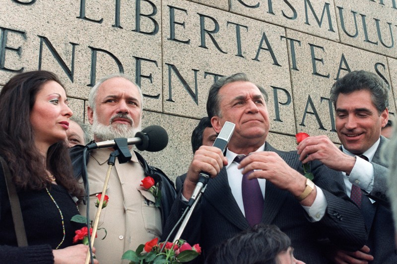 Ion Iliescu, alături de Petre Roman, dreapta și Gelu Voican, la un miting politic pe 27 aprilie 1990, în București. Foto: Andrei Iliescu / AFP / Profimedia