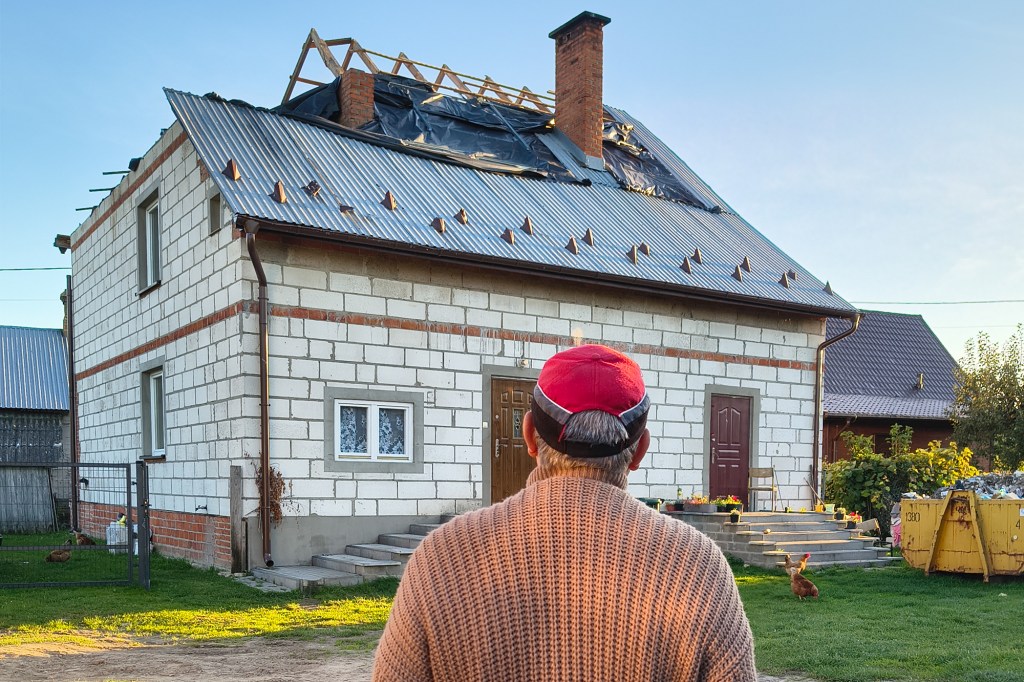 Tomasz Wesolowski în fața casei lui cu acoperișul distrus, în Wyryki-Wola, Polonia. Fotografii de Adelina Mărăcine și Raluca Ion