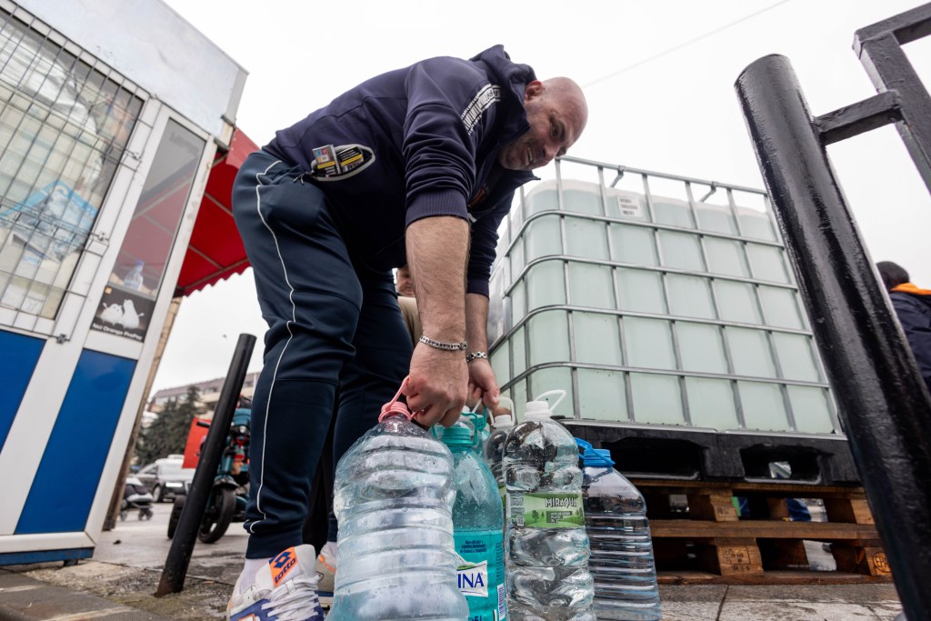 Mai multe persoane așteaptă la rând pentru a umple sticle cu apă potabilă, în orașul Câmpina, luni, 1 decembrie 2025 | Foto:  Inquam Photos / Ovidiu Micsik