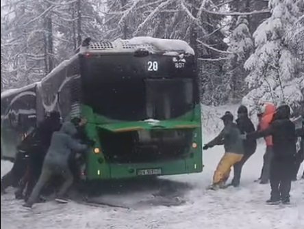 VIDEO Drumul spre Poiana Brașov, acoperit de zăpadă. Un autobuz a rămas împotmolit, fiind împins de călători
