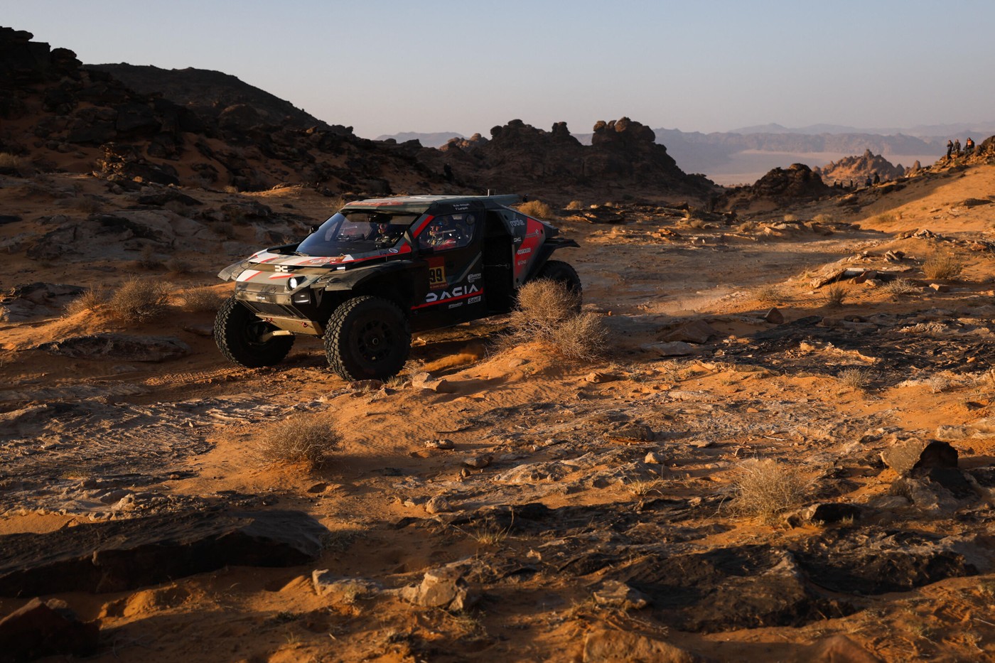 Dacia roșie și albastră în deșertul Arabiei Saudite cu piloții la volan dominând Raliul Dakar după etapa a șasea | sursa foto: HotNews Dacia roșie și albastră în deșertul Arabiei Saudite cu piloții la volan dominând Raliul Dakar după etapa a șasea | sursa foto: HotNews