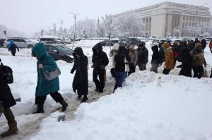 Mai mulți oameni traversează printre nămeți, la Piața Victoriei din București Foto: Inquam Photos / Octav Ganea