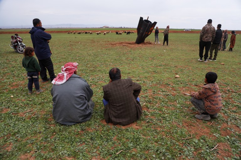 Mai mulți localnici din orașul sirian Qamishli, aflat în estul Siriei, se uită la o rachetă iraniană, rămasă neexplodată Foto: Profimedia