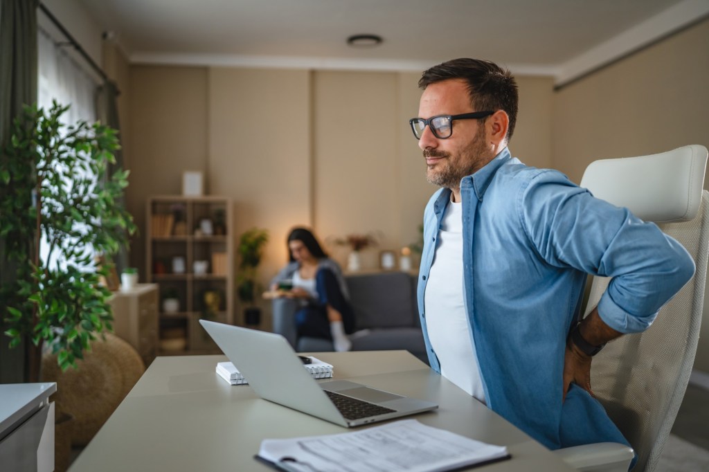 bărbat care muncește la birou cu durere de spate