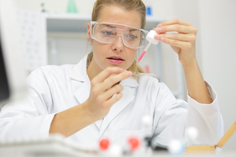 cercetătoare în laborator face un experiment