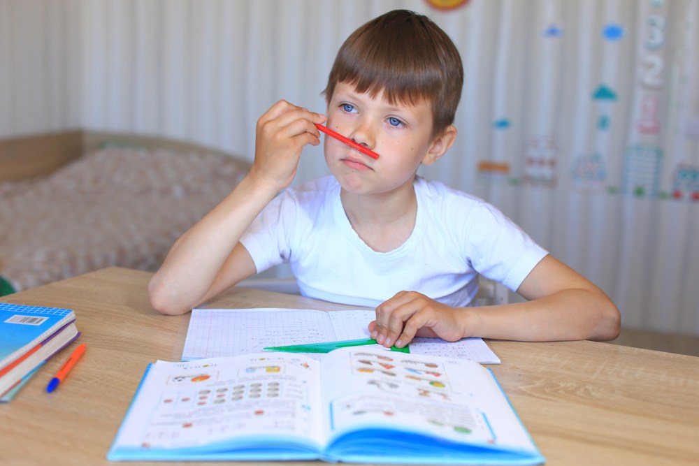 Copilul se uită pe pereți, se ridică de 5 ori să ia apă și e convins că nu mai știe nimic – așa arată momentul primelor teme de după vacanță. FOTO: Shutterstock