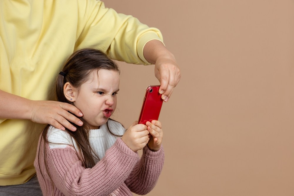 Când copilul e furios că i s-a luat telefonul, explicațiile lungi și logice ale părintelui nu ajută. Însă limita trebuie păstrată. FOTO: Shutterstock