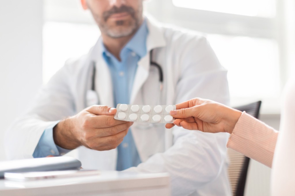 doctor îi dă pastile unei femei de vârstă mijlocie antiîmbătrânire